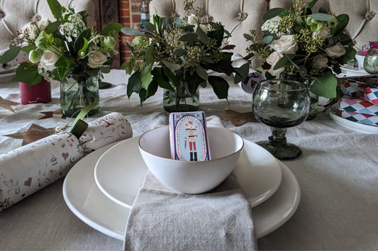 Pod & Pip's Christmas Table, decorated with christmas crackers, candle sticks, floral arrangements and seasonal chocolates