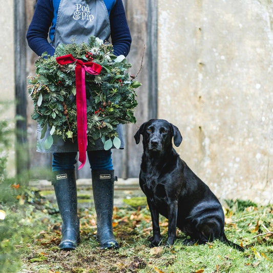 A stunning Chritmas wreath with a red bow, featuring Minnie the dog.